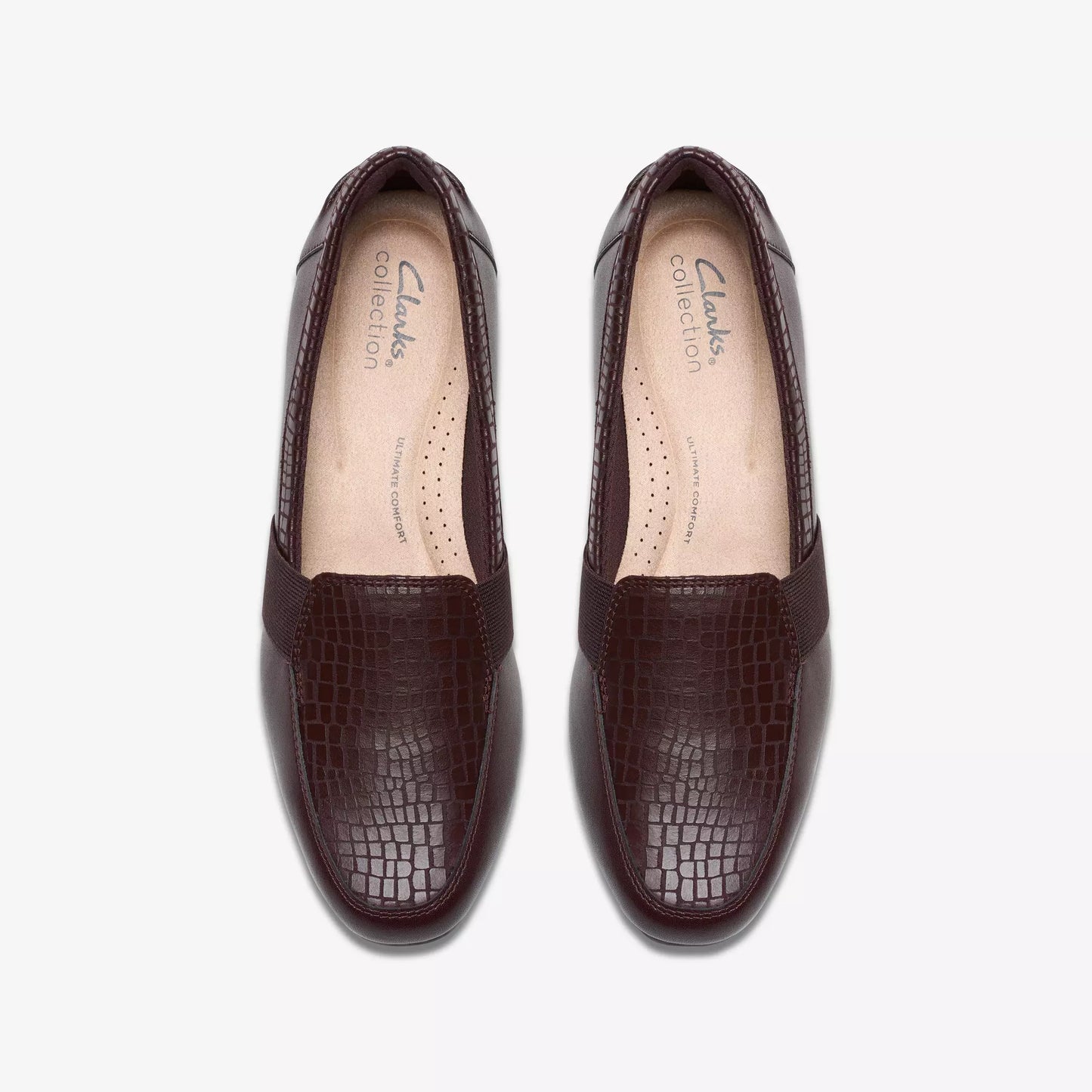 Pair of brown leather slip-on shoes with alligator texture.