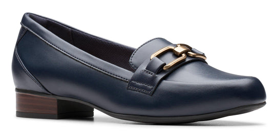 A navy blue loafer with a gold buckle on a low, brown heel.