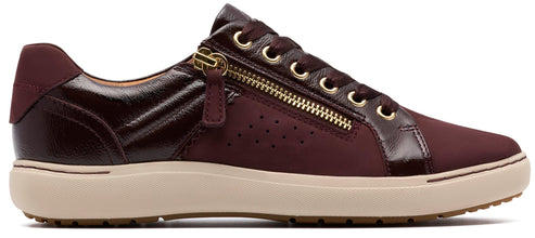 A burgundy sneaker with a gold zipper.
