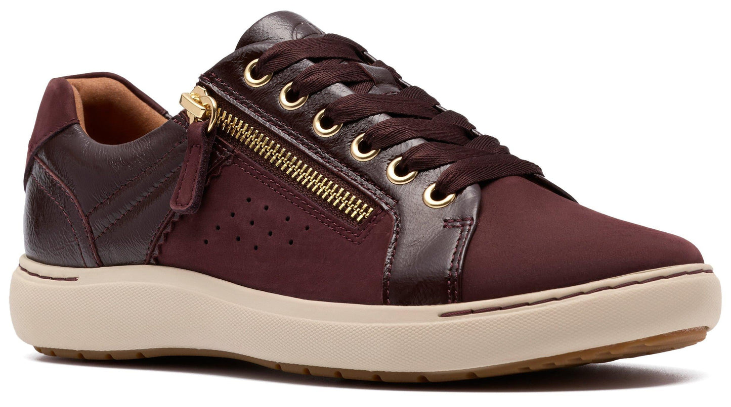 Burgundy sneaker with gold zipper detail and beige sole.