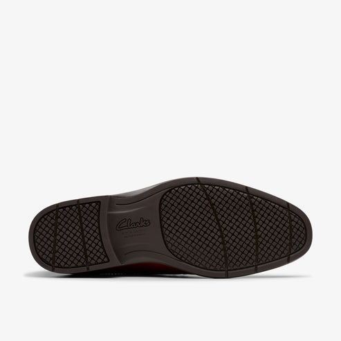 Close-up of a brown shoe's sole with visible brand name 'Clarks'.
