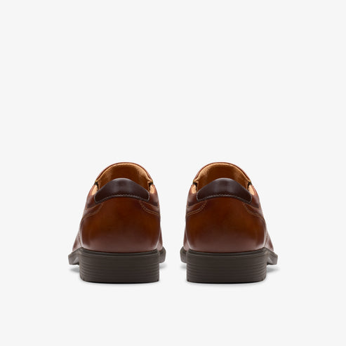 Pair of brown leather dress shoes, rear view.