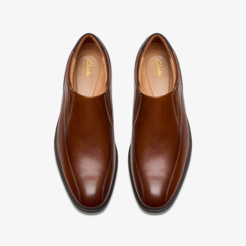 Pair of brown leather slip-on dress shoes with rounded toes.