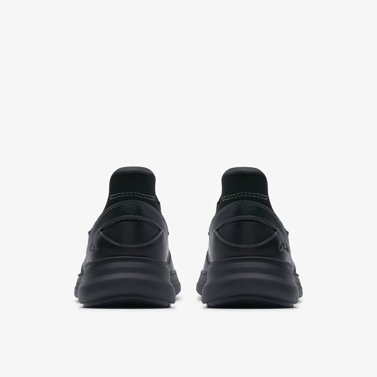 Rear view of two black running shoes with thick black soles.