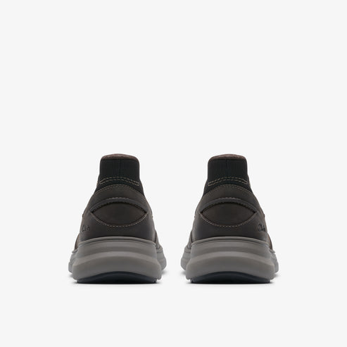 Pair of sock-like dark grey athletic shoes with thick grey soles, rear view.