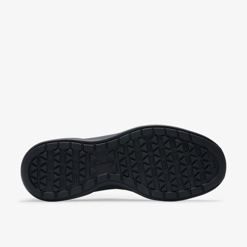 The black rubber outsole of a shoe features a repeating pattern of small triangles.