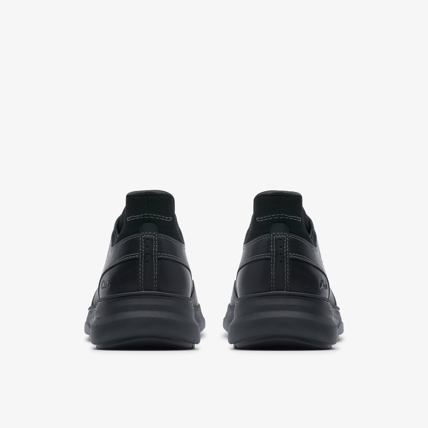 Back view of a pair of black leather shoes with a thick sole.
