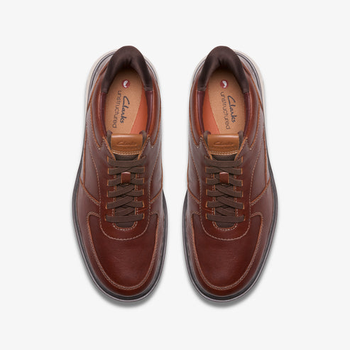 Overhead view of brown leather sneakers with brown laces and padded tan insoles.