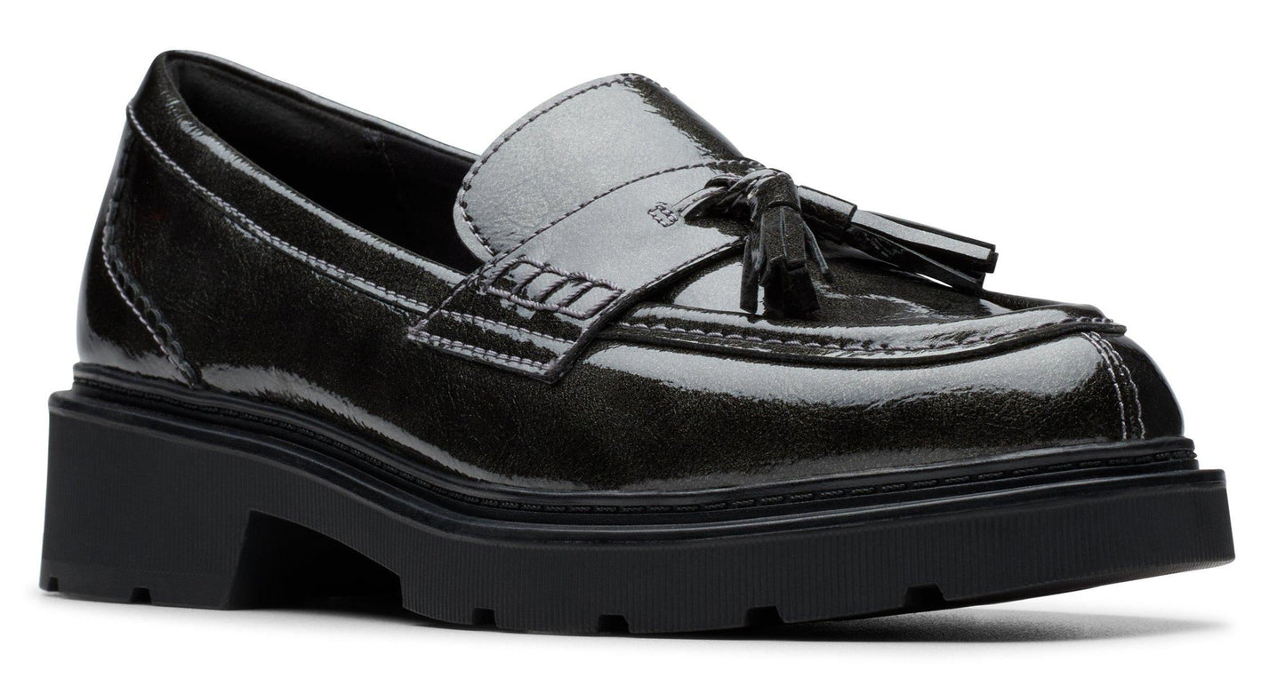 Black patent leather loafer with tassels and a chunky sole.