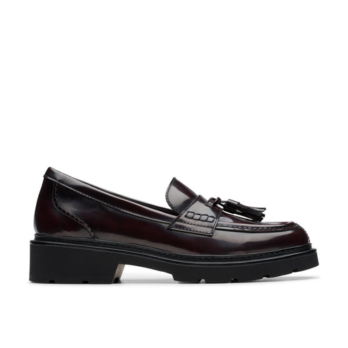 Oxblood leather penny loafer with a stacked heel and tassel embellishment.