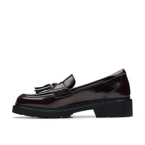 Side view of a dark red leather loafer with a black sole and tassels.