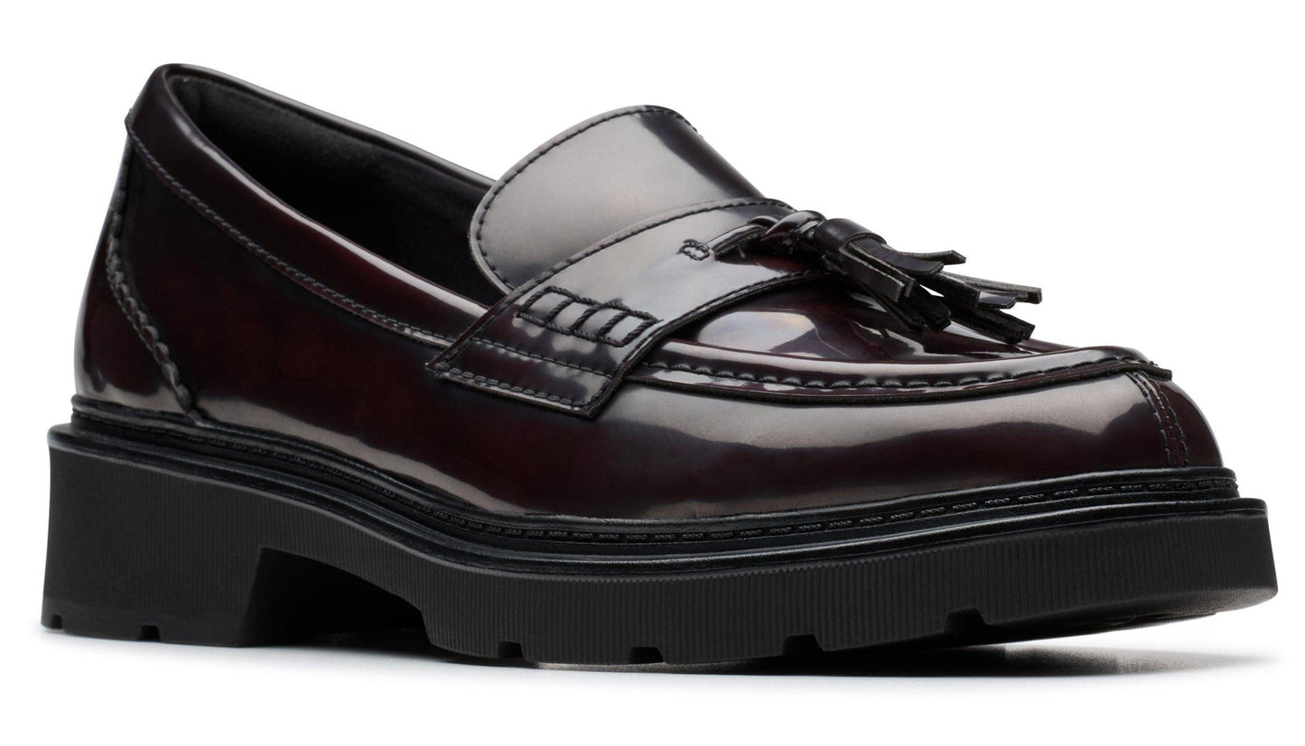 Maroon leather loafer with a tassel and a chunky black sole.