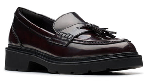 Maroon leather loafer with a tassel and a chunky black sole.