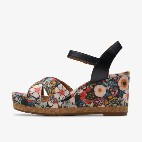 Floral wedge sandal with cork platform and black ankle strap.