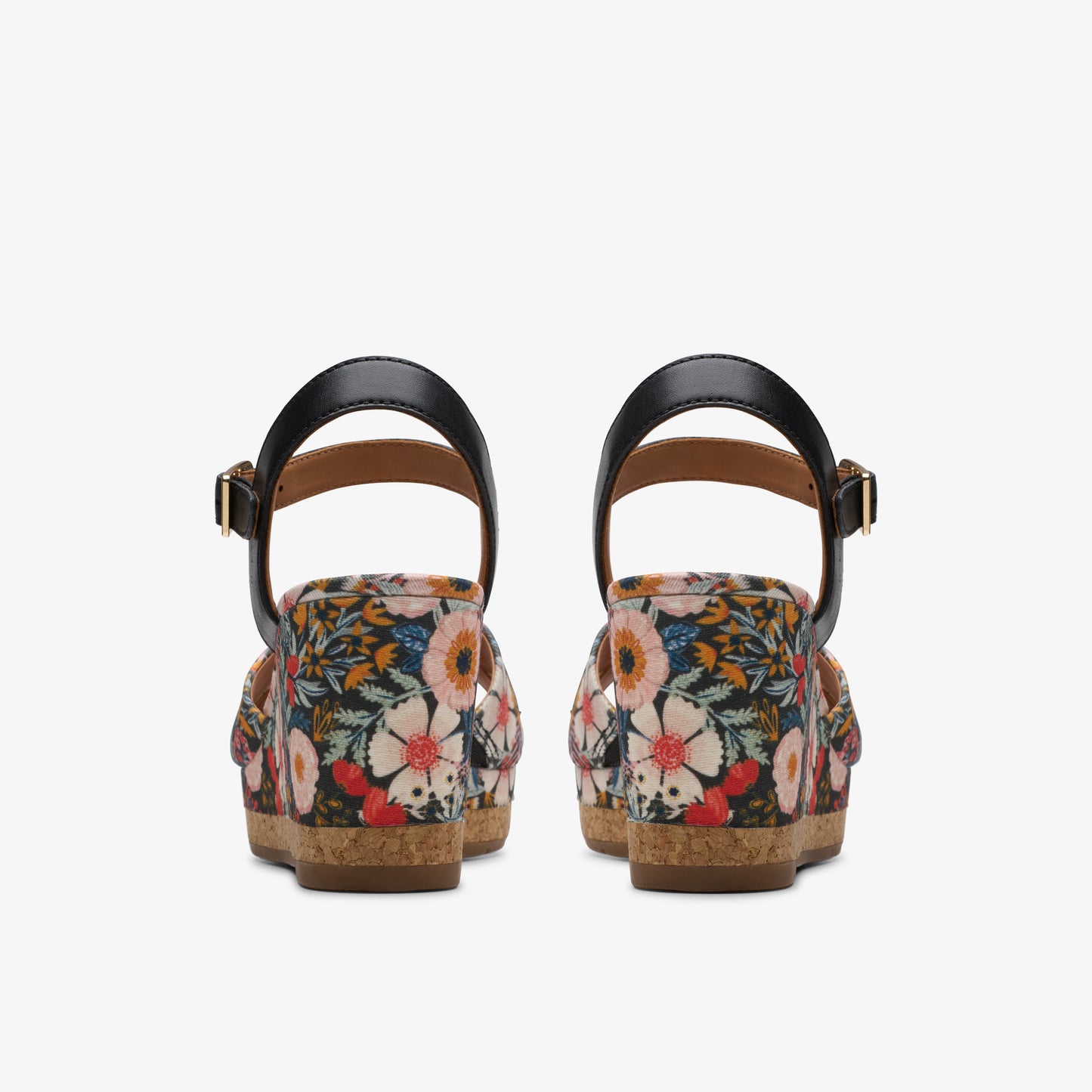 Pair of floral print wedges with black straps, seen from behind.