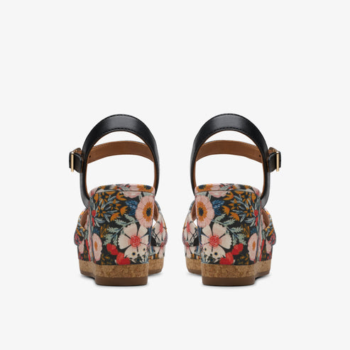 Pair of floral print wedges with black straps, seen from behind.