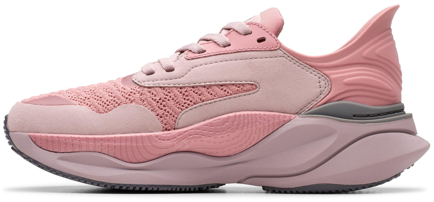 A pink running shoe with a mesh upper and a thick sole.