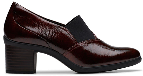 Patent leather burgundy heeled shoe with a rounded toe and a black elastic side panel.
