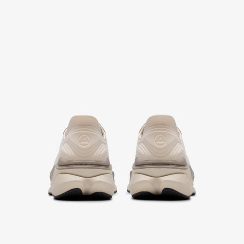 Two identical sneakers with cream-colored uppers and black soles are seen from the rear.