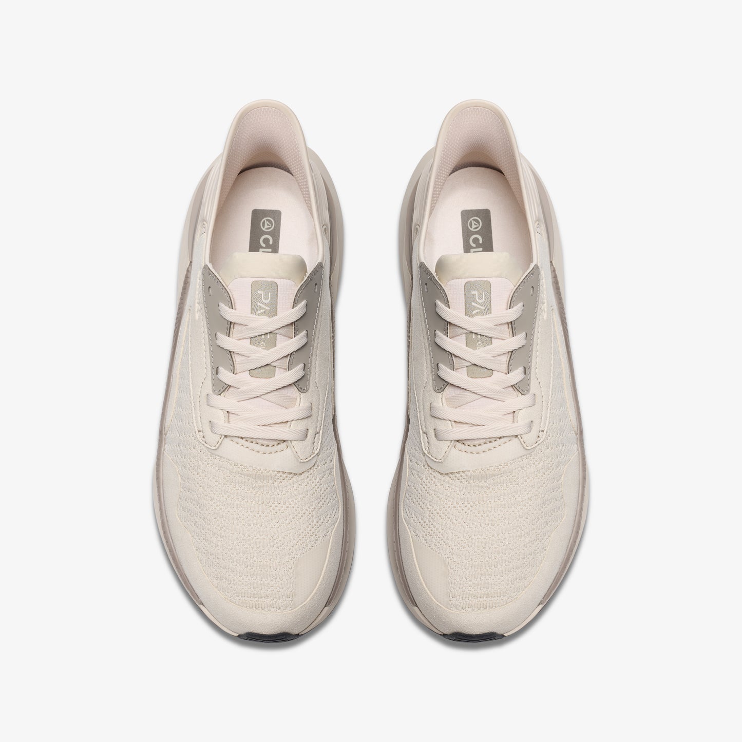 Top-down view of pair of beige athletic shoes with laces.