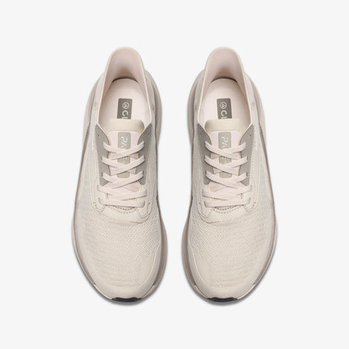 Top-down view of pair of beige athletic shoes with laces.