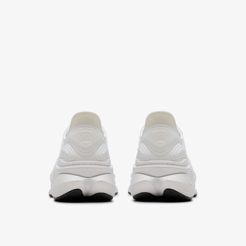 Two white running shoes with black soles facing away from the viewer.