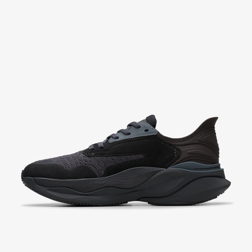 Black running shoe with a wavy sole and a layered upper made of suede and mesh.