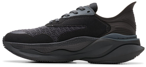 A side-view of a black sneaker with a thick, patterned sole, laces, and a uniquely shaped heel.
