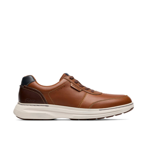 Low top, brown leather sneaker with a white sole and a black heel.