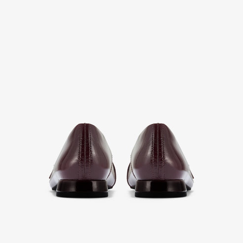 Rear view of a pair of dark red, leather dress shoes with a square heel.