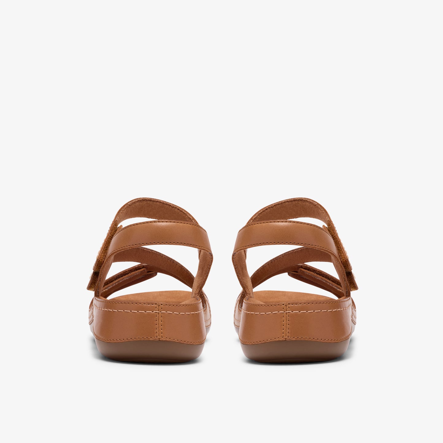 Two women's light-brown sandals with adjustable straps, viewed from the back.