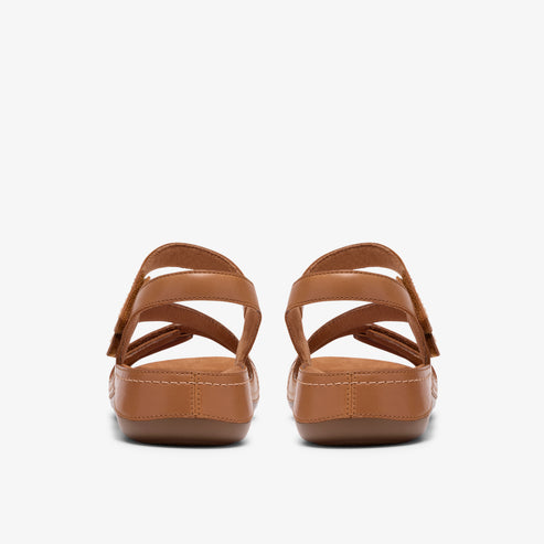Two women's light-brown sandals with adjustable straps, viewed from the back.