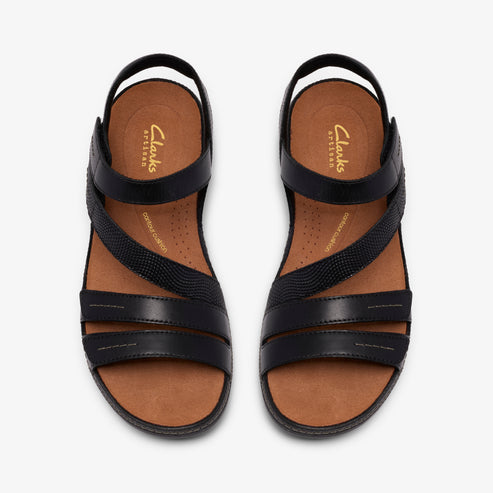 Overhead shot of two black leather sandals with straps; one strap crosses diagonally. Insole reads "Clarks ARTISAN" and "ultimate comfort".