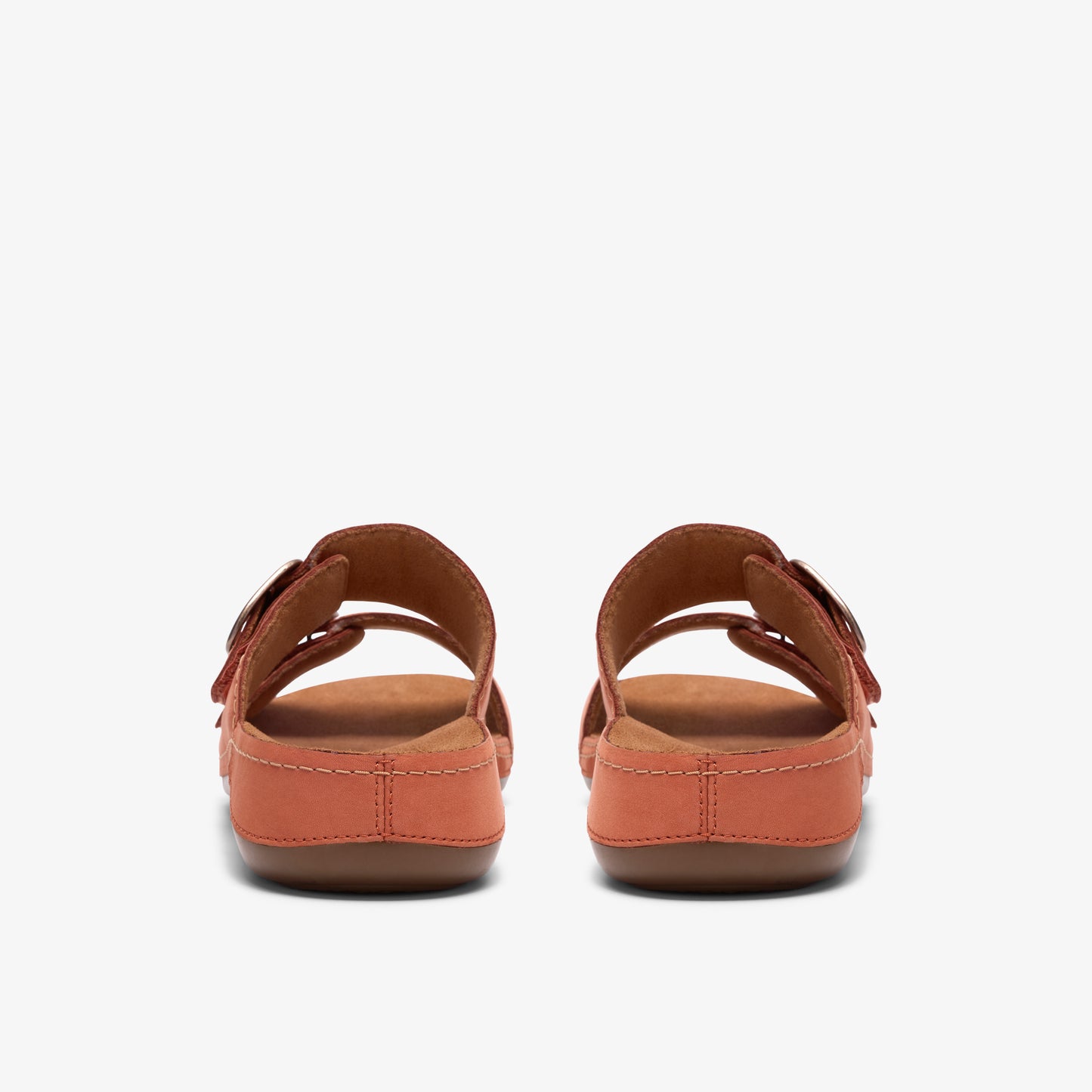 Pair of orange sandals with buckle straps, back view.