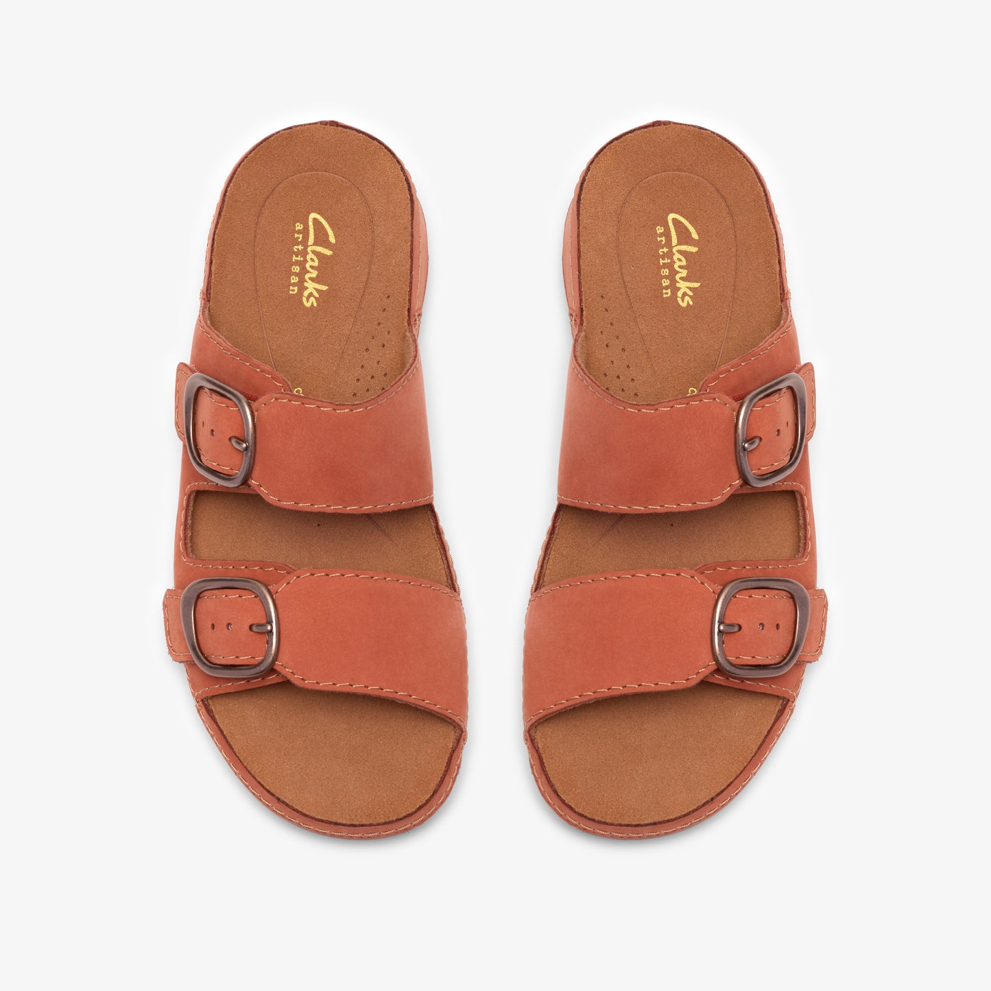 Pair of orange leather sandals with two straps each, each strap featuring a metal buckle. Insole has "Clarks ARTISAN" text.