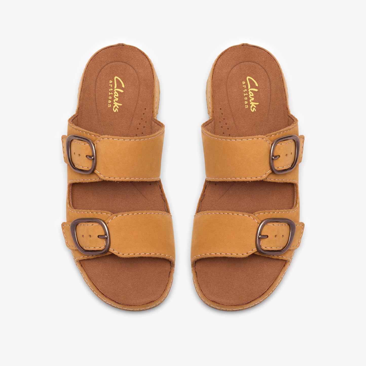 Top-down view of two tan leather sandals with two straps each, and a buckle on each strap. The insole has "Clarks ARTISAN" printed on it.