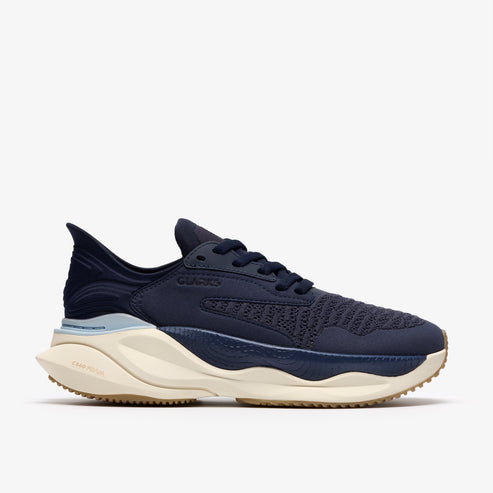 Navy blue sneaker with tan sole and white midsole, 'CLARKS' printed on side.