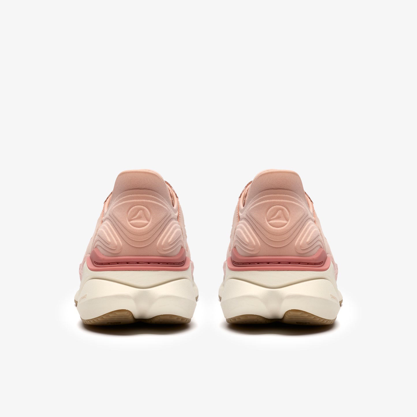 Pair of pink running shoes, seen from behind, with light colored soles.