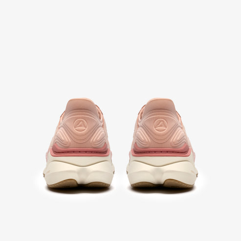 Pair of pink running shoes, seen from behind, with light colored soles.