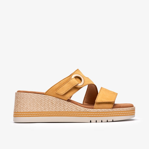 Yellow slide sandal with adjustable straps, wedge heel, and decorative ring.