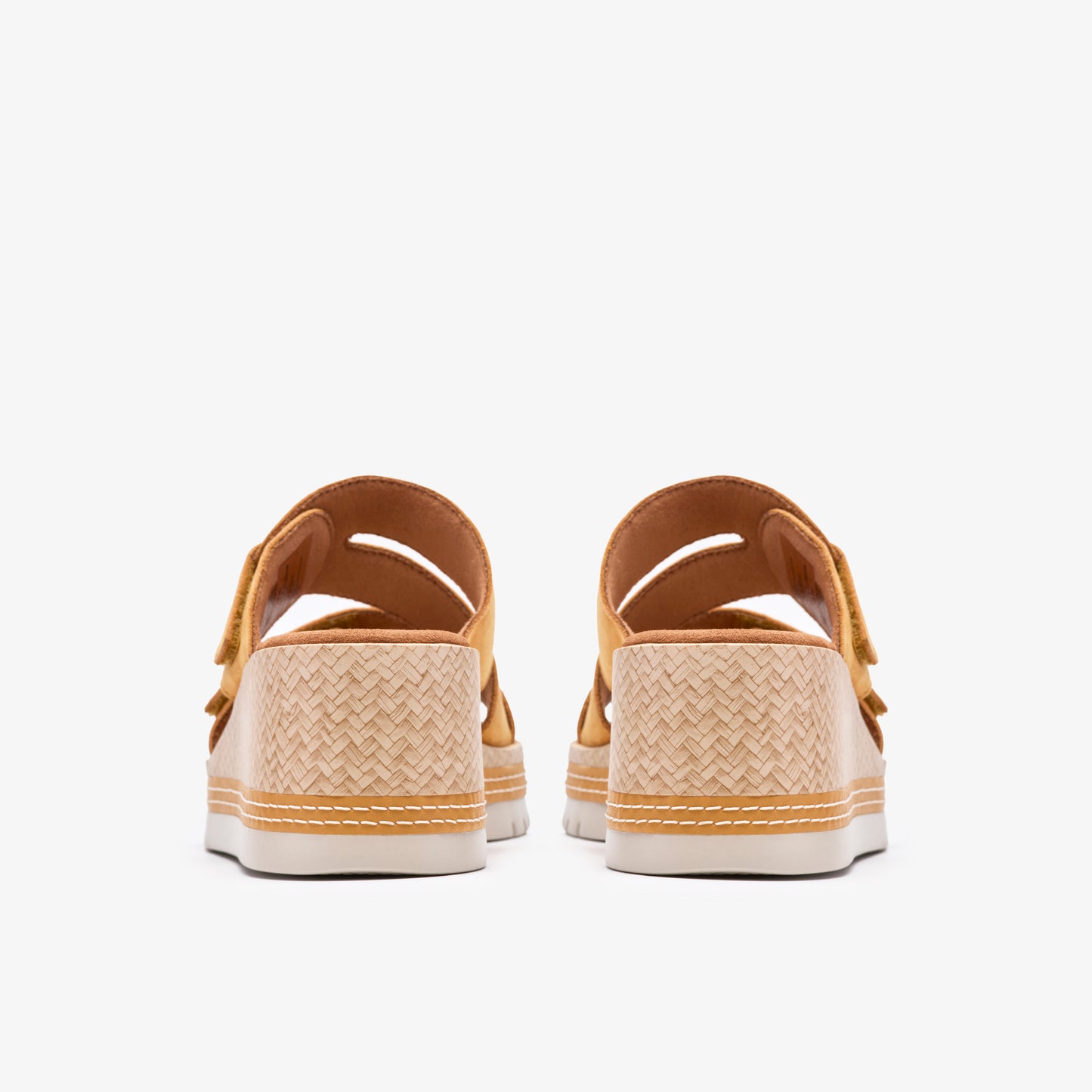 Rear view of two yellow, platform sandals with woven sides and adjustable straps.