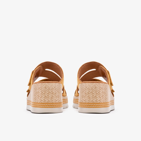 Rear view of two yellow, platform sandals with woven sides and adjustable straps.