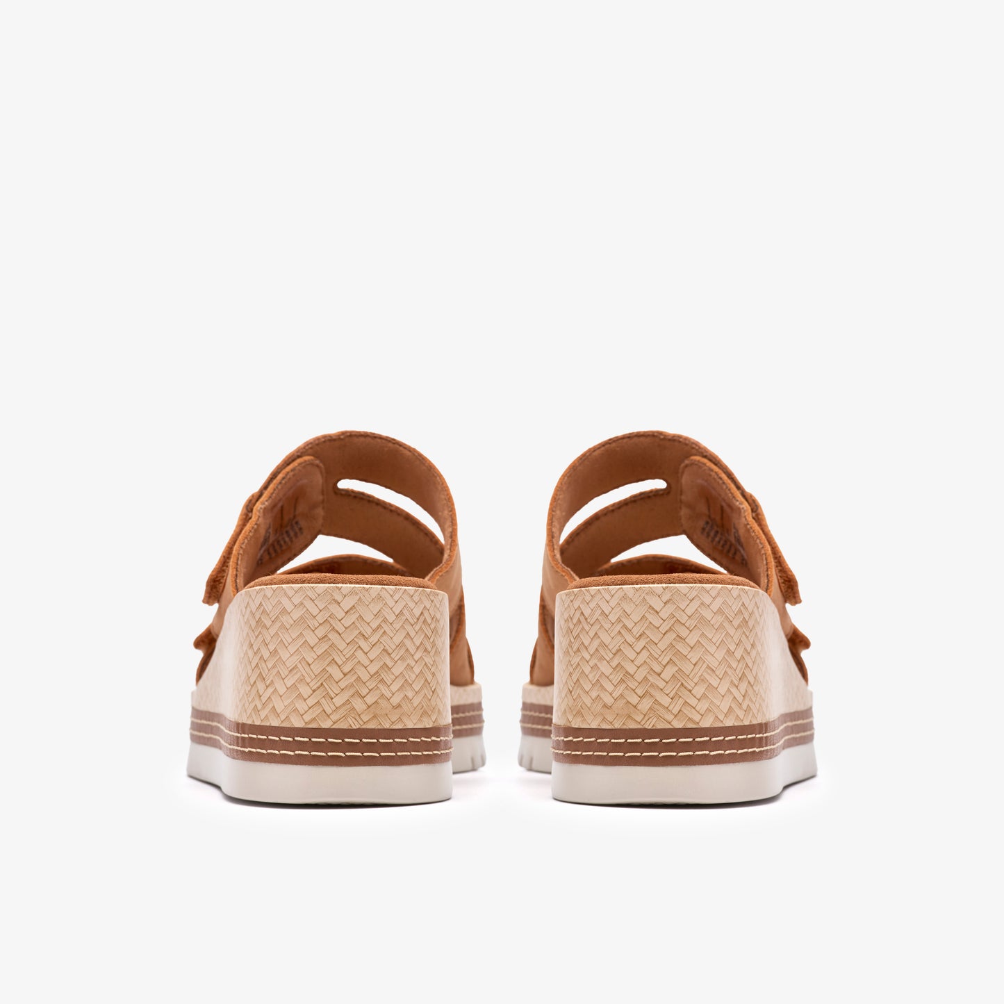 Back view of platform sandals with tan straps and woven textured soles.