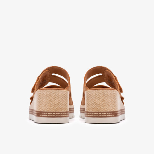Back view of platform sandals with tan straps and woven textured soles.