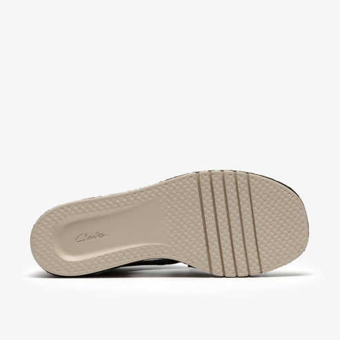 The beige-colored outsole of a shoe with a waffle pattern and several raised ridges.