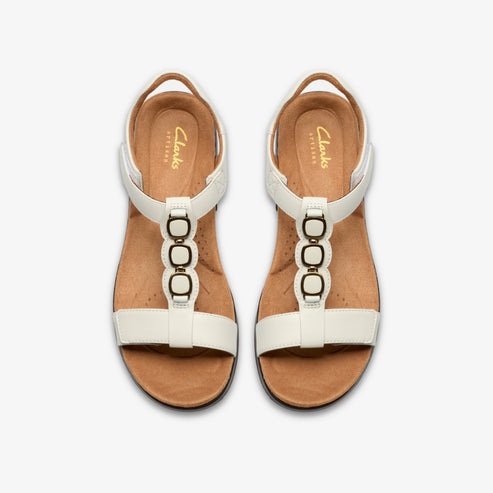 Overhead shot of white sandal shoes with three linked circles.