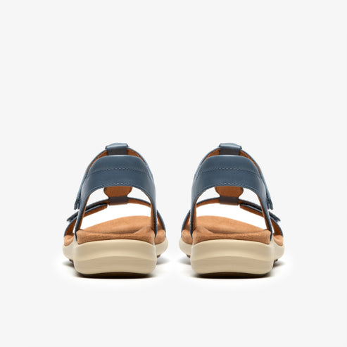 Pair of denim-colored leather sandals with tan insoles and cream soles, rear view.