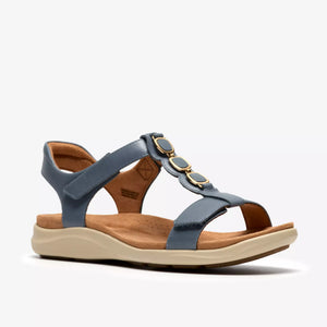 Blue T-strap sandal with circular adornments and an adjustable heel strap.