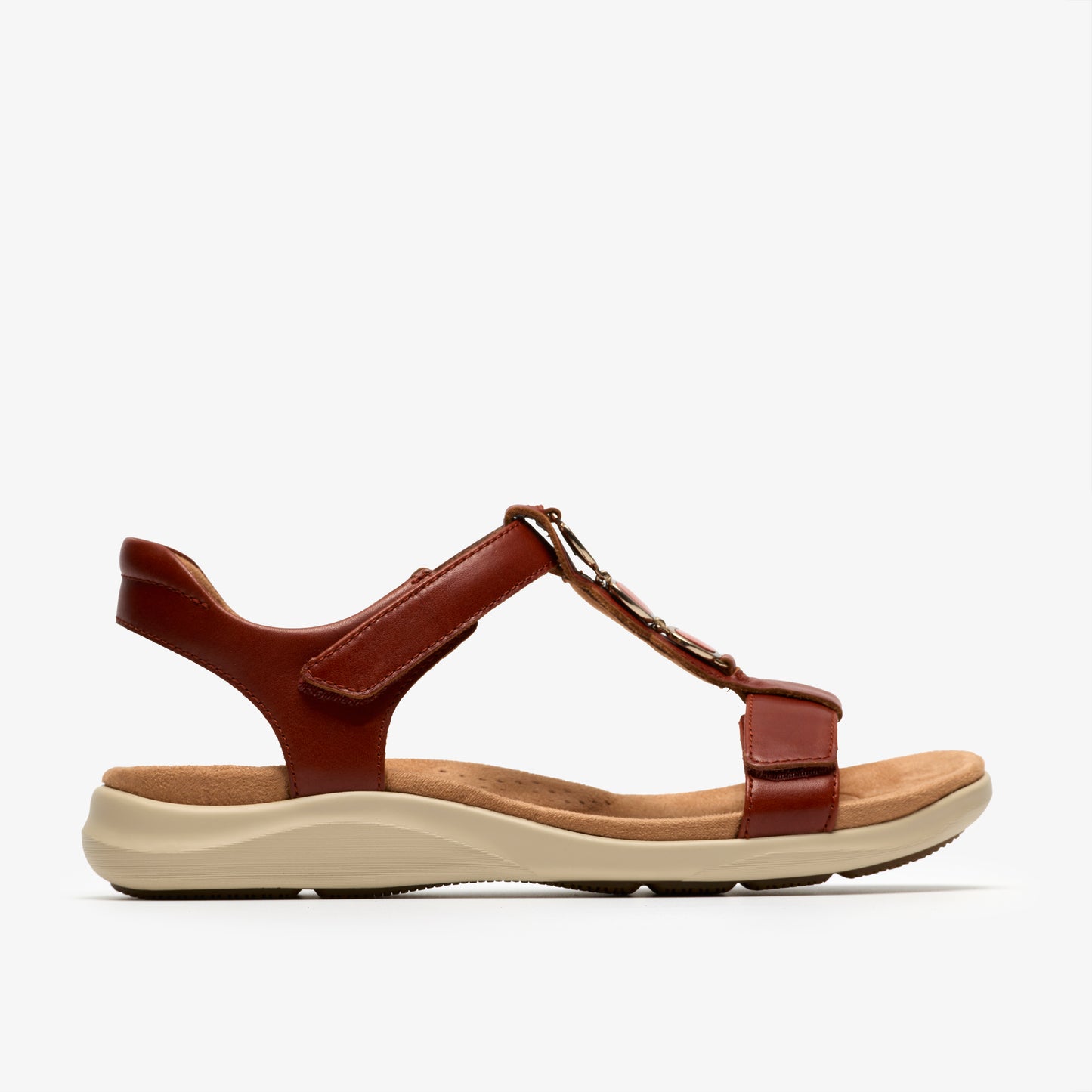 Side view of a brown leather T-strap sandal with an off-white sole.