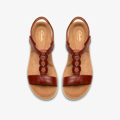 Pair of brown leather T-strap sandals with orange accents and velcro closures, seen from above.